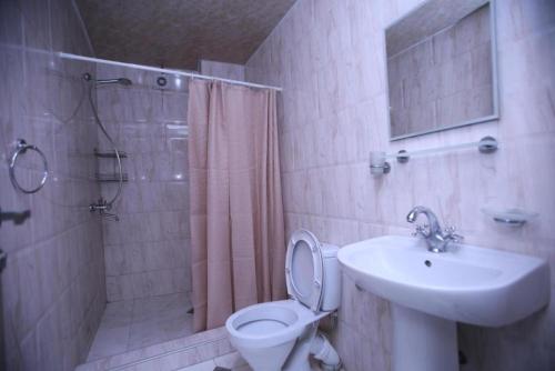 a bathroom with a toilet and a sink and a shower at Green House Hotel N2 in Kobuleti