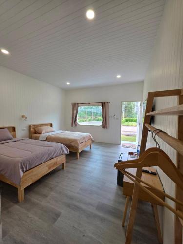 a bedroom with two beds and a window at Kanchana home stay กาญจนา โฮมสเตย์ สุราษฏร์ in Ban Bo Thong