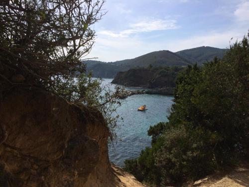 a boat on a river with mountains in the background at Casa Le Agavi in Portoferraio