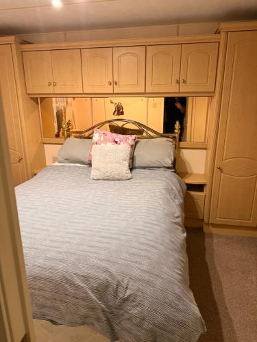 a bed with a pillow on top of it at Sea View Static Caravan With Decking - Skipsea Sands Holiday Park in Skipsea