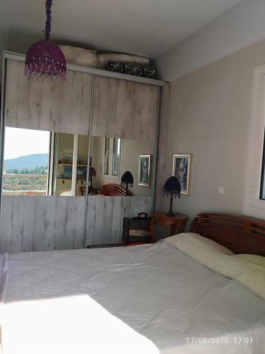 a bedroom with a white bed and a large window at To Fournaraki in Gialiskari