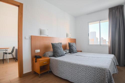 a bedroom with a bed with a wooden headboard at Primavera Loix in Benidorm