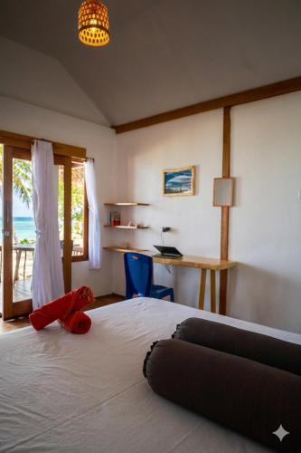 a bedroom with a bed with a stuffed animal on it at Buggei Surfcamp Mentawai in Katiet