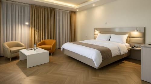 a hotel room with a large bed and a chair at Golden Gate Hotel Hawassa in Āwasa