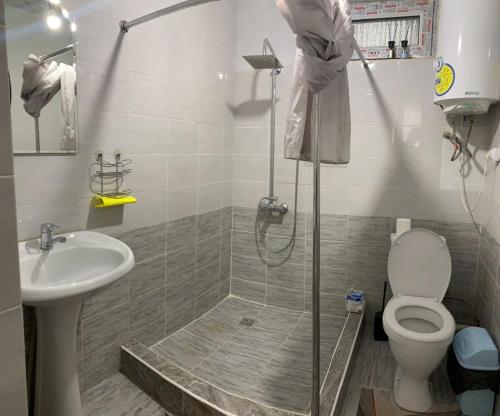 a bathroom with a shower and a toilet and a sink at Rest House in Cholpon-Ata