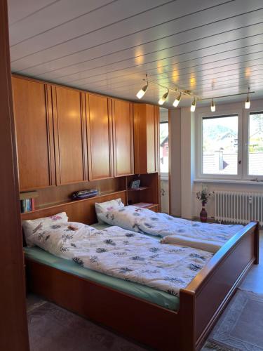 a bedroom with a large bed with a wooden headboard at Waldblick-Appartement in Baiersbronn