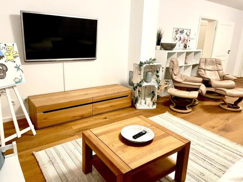 a living room with a television and a coffee table at Gemütliche Ferienwohnung Casa Caliora, 8km zum Biggesee in Drolshagen