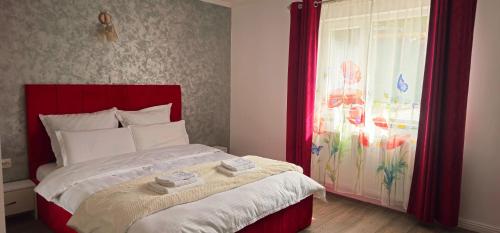 a bedroom with a bed with a red headboard and a window at Belvedere Panaci in Coverca