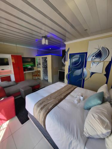 a bedroom with a large bed and a couch at The wood Guest house in Pretoria