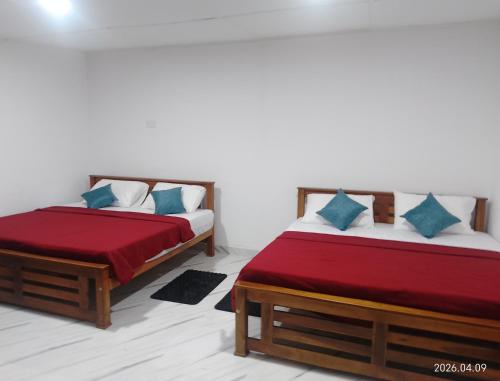 two beds sitting next to each other in a room at Tea Vibe Bungalow Malwatte in Bandarawela