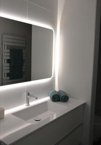 a bathroom with a sink with a mirror and towels at Haus Gruber in Attersee am Attersee