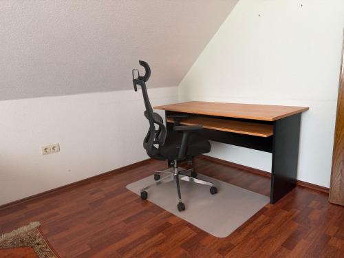 a desk with a chair in a room at Burato`s Haus in Minden