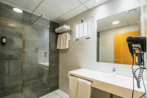 a bathroom with a shower and a sink and a mirror at Primavera Loix in Benidorm