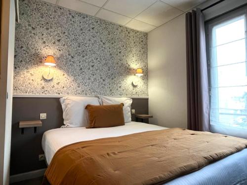 a bedroom with a bed and two lights on the wall at Hôtel Maisons Delphine - Le Cottage in Villers-sur-Mer