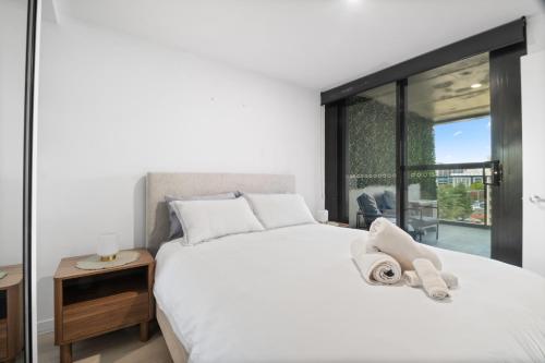 a bedroom with a large white bed with a window at Premium 2BR Braddon, Marriott Amenities in Braddon