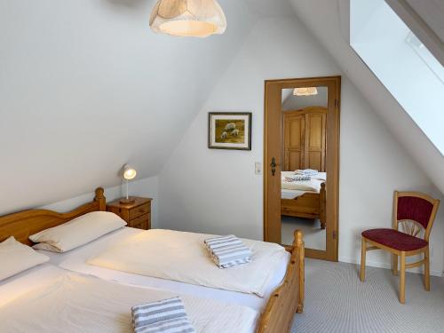 a bedroom with two beds and a mirror at Haus *Üüs Aran* Wohnung Nr. 6 in Nebel