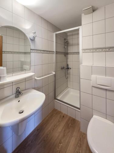 a bathroom with a sink and a shower and a toilet at Haus *Üüs Aran* Wohnung Nr. 6 in Nebel