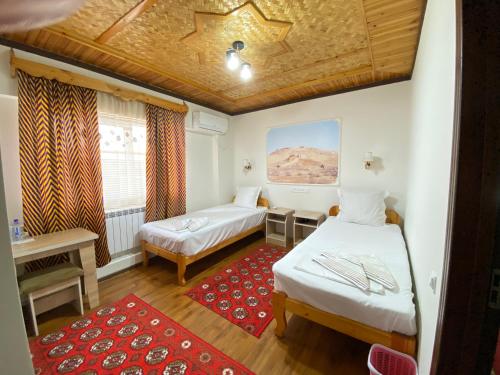 a room with two beds and a red rug at XIVA AZIM OTA in Khiva