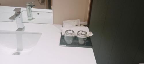 a bathroom with a sink with two cups on a tray at Khampiane Hotel in Vientiane