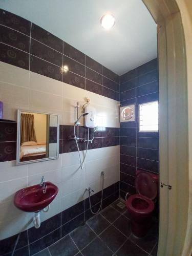 a bathroom with a red toilet and a sink at mulia homestay in Teluk Intan