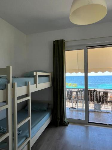 a bedroom with bunk beds and a view of the ocean at Oasis on the Beach in Himare