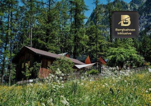a sign for a log cabin in a forest at Älmele - Waldchalets Brandnertal in Brand