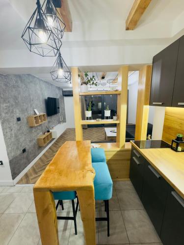 a kitchen with a wooden table and blue chairs at Luna Apartman in Višegrad