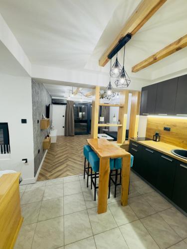 a kitchen with a wooden table and blue chairs at Luna Apartman in Višegrad