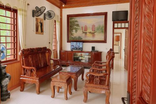 a living room with wooden furniture and a table at Pham's Homestay in Île de Trà Cổ