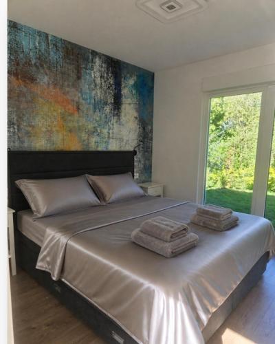 a bedroom with a large bed with towels on it at Vila Green Silence in Pazin