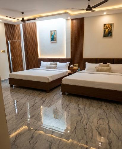 two beds in a hotel room with two beds sidx sidx sidx at Hotel Sooryavanshi in Ayodhya
