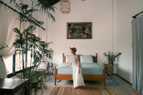 a woman standing on a bed in a room at Neverland de Papillons in Sa Ðéc