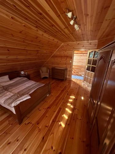 a bedroom with a bed in a wooden cabin at Summer house near the forest in Dybki