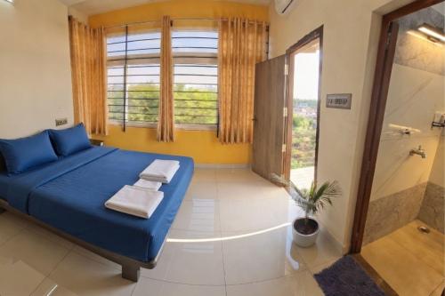 a bedroom with a blue bed and a shower at The Sparrow in Kanyakumari