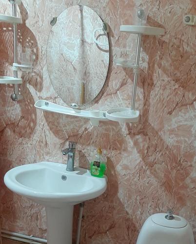 a bathroom with a sink and a mirror and a toilet at Hotel MANTASHOV in Meghri