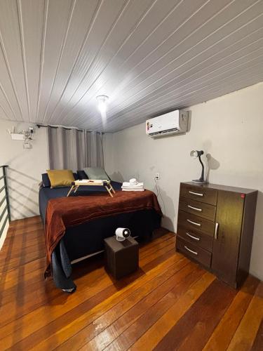 a bedroom with a bed and a dresser in it at Loft com vista para as montanhas in Chapada dos Guimarães