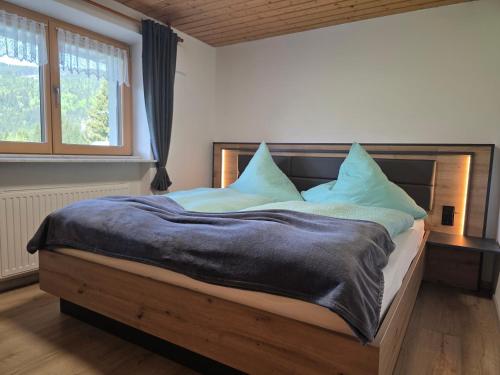 a bedroom with a large bed with blue pillows at Walser Auszeit in Riezlern