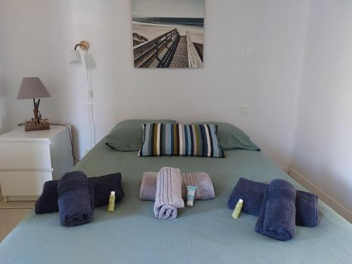 a bed with towels and pillows on it at chalet la rose des sables in Labenne