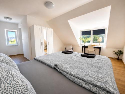 ein Schlafzimmer mit einem großen Bett und zwei Stühlen in der Unterkunft Biomade in Prag