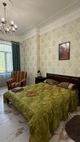 a bedroom with a large bed with a green blanket at Апартаменти в парку in Uman
