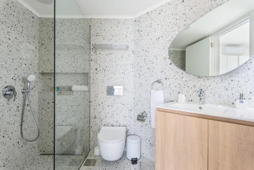 a bathroom with a shower and a toilet and a sink at Bay B Blu,Modern 1BR Chalet -Seaview in Ed Dkârîne
