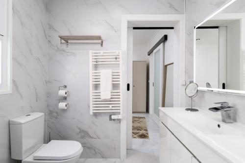 a white bathroom with a toilet and a sink at Villa Aurora in Livramento