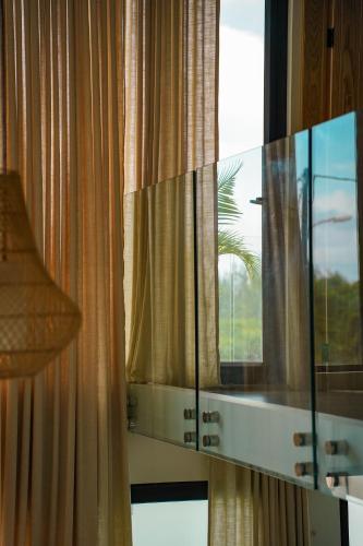 a mirror on a wall in a room with a window at Anba Solēy in Surinam