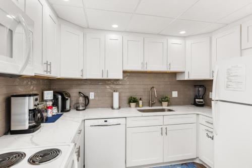 a white kitchen with white cabinets and appliances at Late August Labor Day Deals! Ocean Block Sleeps 6 Beach Gear in Ocean City