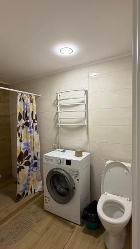a bathroom with a washing machine and a toilet at Апартаменти в парку in Uman