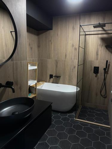 a bathroom with a bath tub and a sink at Soho Apartment Fial in Bacău