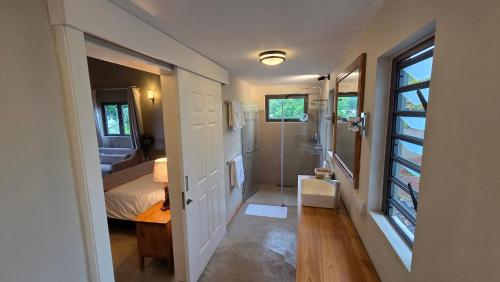 a small bathroom with a bed and a shower at Terganic Farmstay in Grand Sable