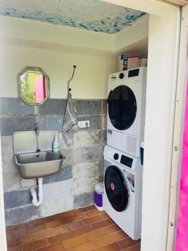 a bathroom with a sink and a washing machine at Bauwagen, Tiny House in Warnitz am Oberuckersee in Melzow