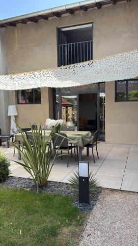 a patio with a table and chairs in front of a house at Le 1881 Ampuis in Ampuis