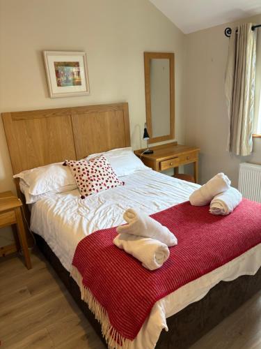 a bedroom with a bed with towels on it at Roundstone Retreats Abbys cottage in Roundstone
